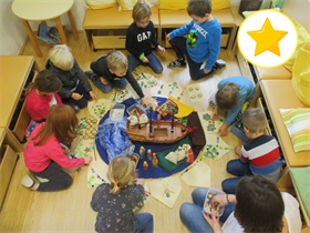 Eine Gruppe von Kindern spielt mit einem Puzzle